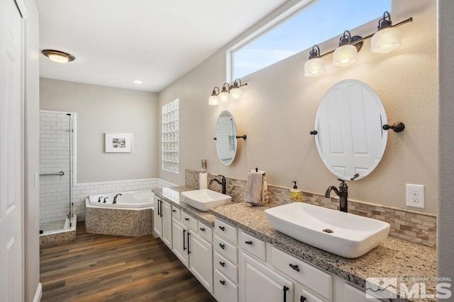 4822 Ramcreek Trl, Reno, NV 89519 - full bathroom with wood finished floors, a garden tub, decorative backsplash, a shower stall, and double vanity