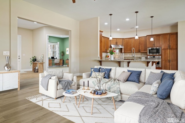 living room with light wood-style flooring, baseboards, and recessed lighting