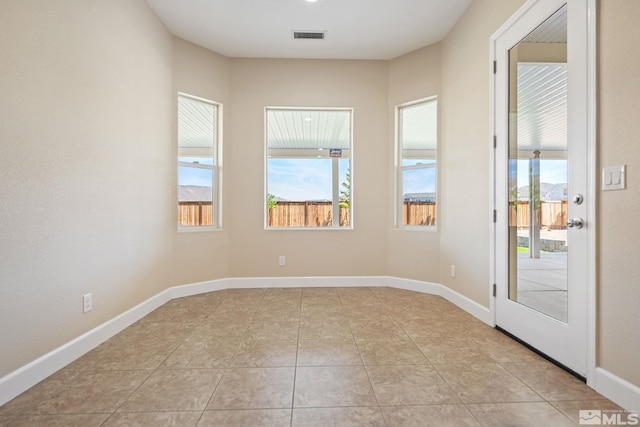 unfurnished room with light tile patterned floors and baseboards