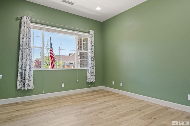 spare room with wood finished floors and baseboards