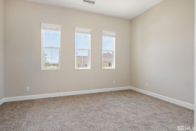 unfurnished room featuring plenty of natural light, carpet flooring, and baseboards