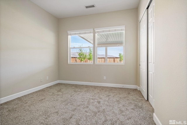 unfurnished bedroom with carpet flooring, baseboards, and a closet