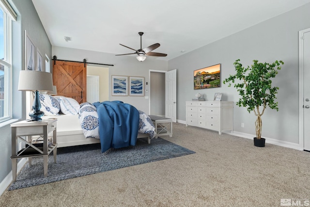 bedroom featuring carpet flooring, a barn door, baseboards, and a ceiling fan