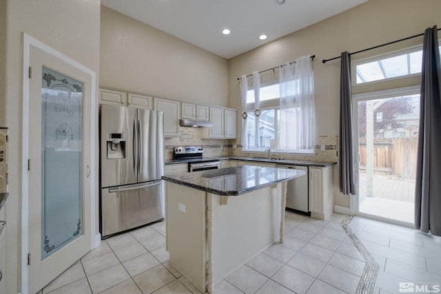 250 Corral Dr, Dayton, NV 89403 - kitchen with appliances with stainless steel finishes, a center island, a sink, tasteful backsplash, and under cabinet range hood
