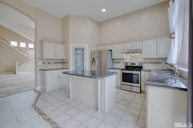250 Corral Dr, Dayton, NV 89403 - kitchen featuring a sink, appliances with stainless steel finishes, a towering ceiling, backsplash, and dark stone counters