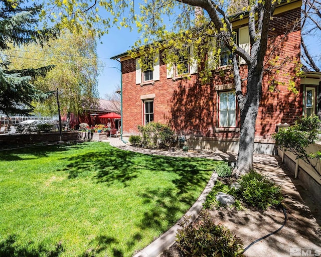308 Thompson, Carson City, NV 89703 - view of front of home with brick siding, a front lawn, and a patio area