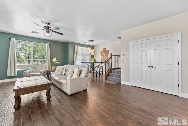 living room with wood finished floors, a ceiling fan, stairway, baseboards, and a textured ceiling