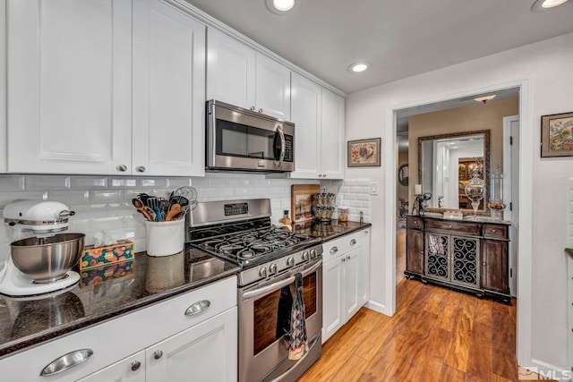 1509 Palo Verde, Carson City, NV 89703 - kitchen with appliances with stainless steel finishes, white cabinets, light wood finished floors, decorative backsplash, and recessed lighting