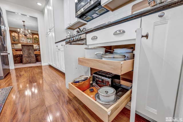 1509 Palo Verde, Carson City, NV 89703 - detailed view of appliances with stainless steel finishes, a chandelier, white cabinets, light wood-style flooring, and recessed lighting