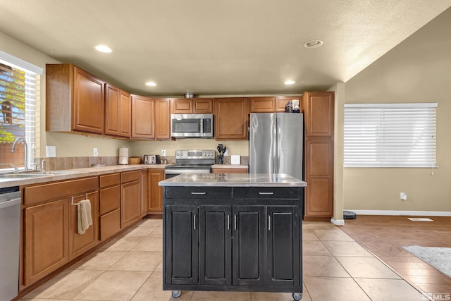 1874 Rosemary Dr, Sparks, NV 89434 - kitchen featuring appliances with stainless steel finishes, a sink, light countertops, a kitchen island, and light tile patterned flooring