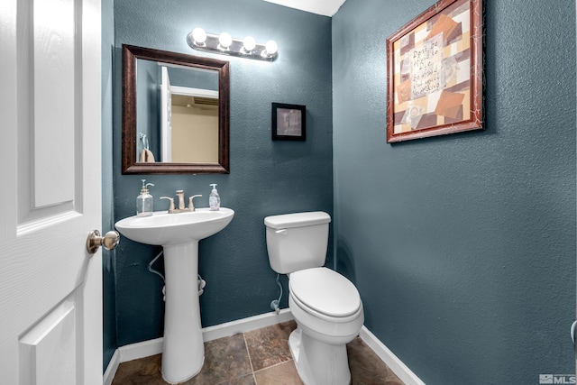 1874 Rosemary Dr, Sparks, NV 89434 - half bathroom with baseboards, toilet, stone finish flooring, and a sink