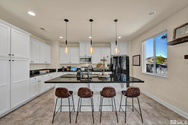 4184 Passage Dr, Sparks, NV 89436 - kitchen featuring freestanding refrigerator, stainless steel microwave, a kitchen bar, white cabinets, and recessed lighting