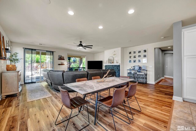4184 Passage Dr, Sparks, NV 89436 - dining area featuring light wood finished floors, ceiling fan, a stone fireplace, recessed lighting, and baseboards