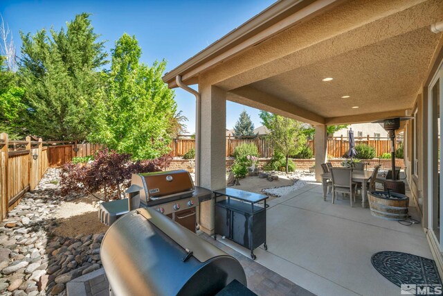4184 Passage Dr, Sparks, NV 89436 - view of patio with outdoor dining area, a fenced backyard, and a grill
