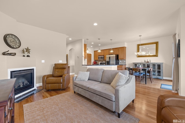 785 Sarcinella Ct, Reno, NV 89509 - living room featuring baseboards, a chandelier, light wood-style floors, a glass covered fireplace, and recessed lighting