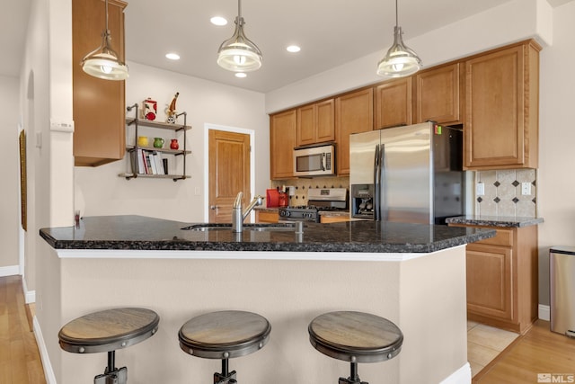 785 Sarcinella Ct, Reno, NV 89509 - kitchen with stainless steel appliances, a sink, light wood-type flooring, a kitchen bar, and backsplash