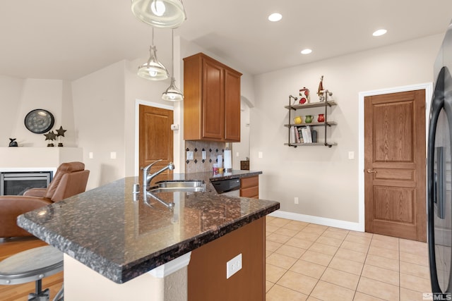 785 Sarcinella Ct, Reno, NV 89509 - kitchen with a sink, brown cabinets, light tile patterned floors, a peninsula, and a breakfast bar area