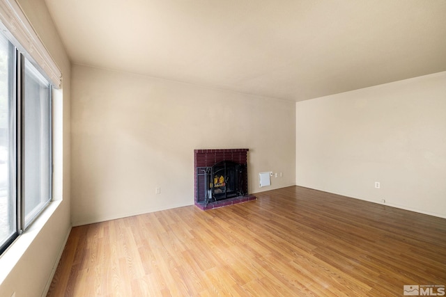 4545 Reggie Rd, Reno, NV 89502 - unfurnished living room featuring healthy amount of natural light, light wood-style flooring, and a brick fireplace