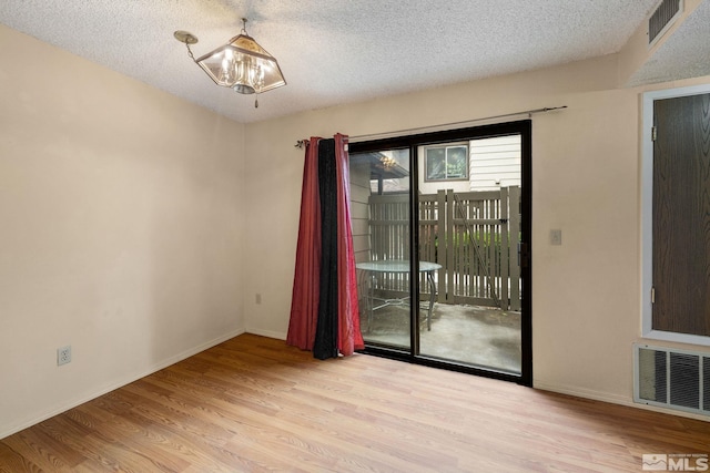 4545 Reggie Rd, Reno, NV 89502 - empty room featuring wood finished floors, a textured ceiling, a chandelier, and baseboards