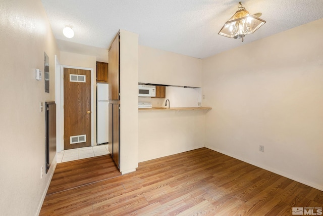 4545 Reggie Rd, Reno, NV 89502 - unfurnished dining area with light wood-style floors and a textured ceiling