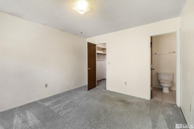 4545 Reggie Rd, Reno, NV 89502 - unfurnished bedroom featuring carpet, ensuite bath, a textured ceiling, and a spacious closet