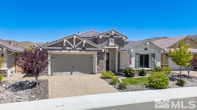 9680 Thesolious Ln, Reno, NV 89521 - view of front of home featuring a garage, stucco siding, decorative driveway, and stone siding