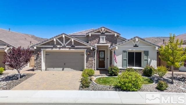 9680 Thesolious Ln, Reno, NV 89521 - craftsman inspired home with stone siding, an attached garage, driveway, stucco siding, and a tiled roof