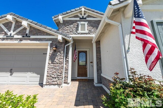 9680 Thesolious Ln, Reno, NV 89521 - view of exterior entry featuring stone siding and an attached garage