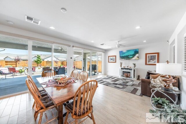 9680 Thesolious Ln, Reno, NV 89521 - dining area featuring ceiling fan, recessed lighting, light wood-style flooring, and a glass covered fireplace