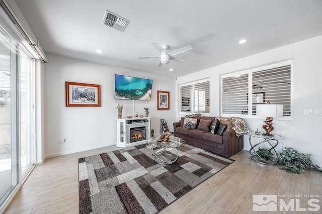 9680 Thesolious Ln, Reno, NV 89521 - living area with wood finished floors, a ceiling fan, recessed lighting, and a glass covered fireplace