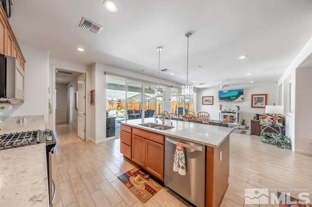 9680 Thesolious Ln, Reno, NV 89521 - kitchen featuring appliances with stainless steel finishes, a sink, light wood-type flooring, brown cabinets, and recessed lighting