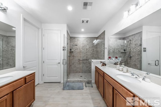 9680 Thesolious Ln, Reno, NV 89521 - bathroom featuring a stall shower, vanity, wood finished floors, and recessed lighting