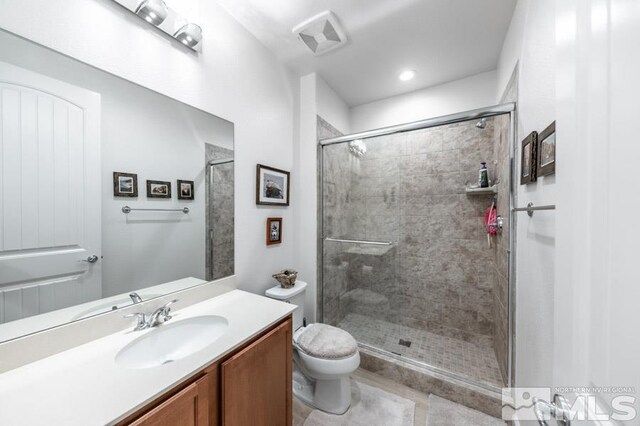 9680 Thesolious Ln, Reno, NV 89521 - full bathroom featuring a stall shower, toilet, vanity, and tile patterned flooring