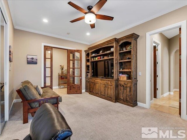 living room featuring french doors, ceiling fan, light colored carpet, arched walkways, and ornamental molding