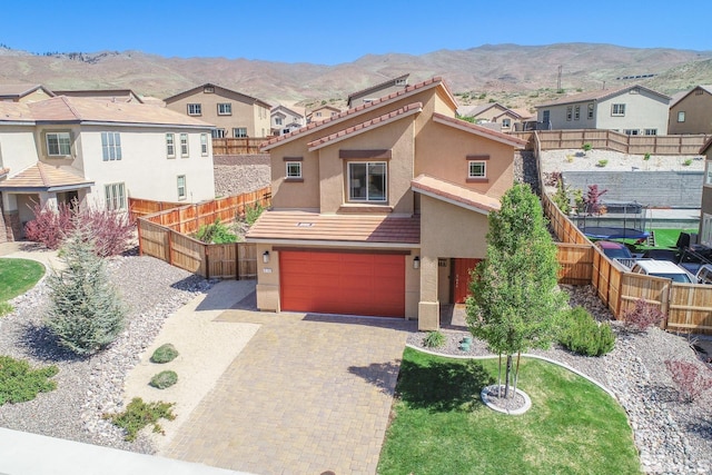 8139 Dornoch Dr, Reno, NV 89439 - view of front of home featuring stucco siding, a mountain view, a garage, and decorative driveway