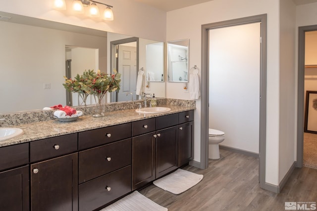 8139 Dornoch Dr, Reno, NV 89439 - full bathroom featuring wood finished floors, toilet, double vanity, and baseboards