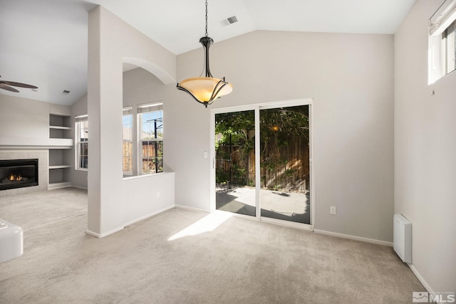 empty room with plenty of natural light, carpet flooring, a ceiling fan, and high vaulted ceiling