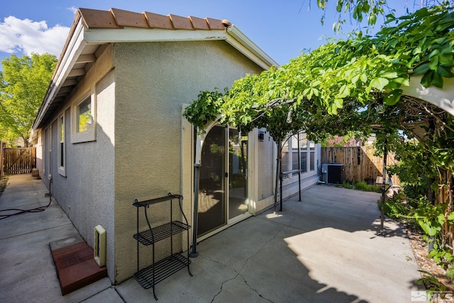 back of property with stucco siding, a patio area, a fenced backyard, and central AC