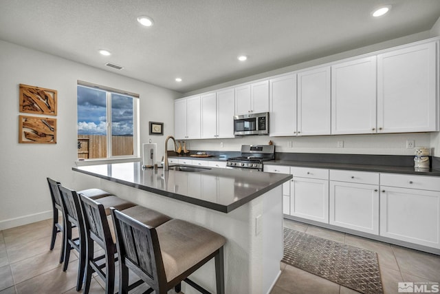 103 Pilot Peak, Carson City, NV 89701 - kitchen featuring appliances with stainless steel finishes, dark countertops, a sink, recessed lighting, and an island with sink
