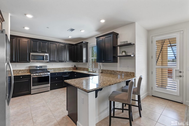 3097 Livorno Dr, Sparks, NV 89434 - kitchen with stainless steel appliances, a peninsula, stone counters, a sink, and a breakfast bar area