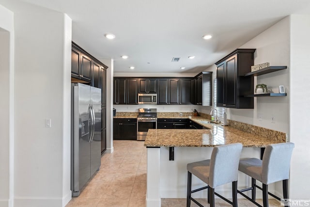 3097 Livorno Dr, Sparks, NV 89434 - kitchen featuring stainless steel appliances, a sink, a peninsula, light stone countertops, and open shelves