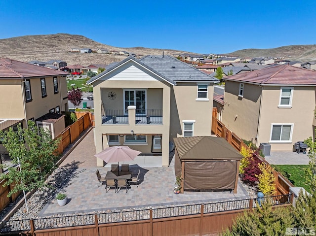 3097 Livorno Dr, Sparks, NV 89434 - rear view of property with a balcony, a fenced backyard, a residential view, stucco siding, and a mountain view