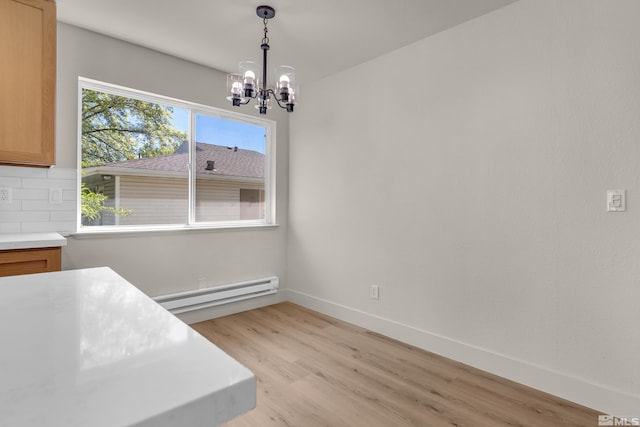 745 Jamaica Ave Unit 4, Reno, NV 89502 - unfurnished dining area featuring a baseboard heating unit, light wood-style flooring, a chandelier, and baseboards