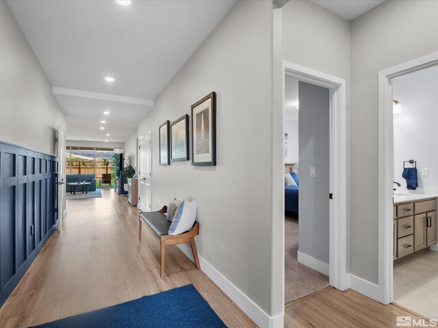 hallway with light wood-type flooring, baseboards, and recessed lighting