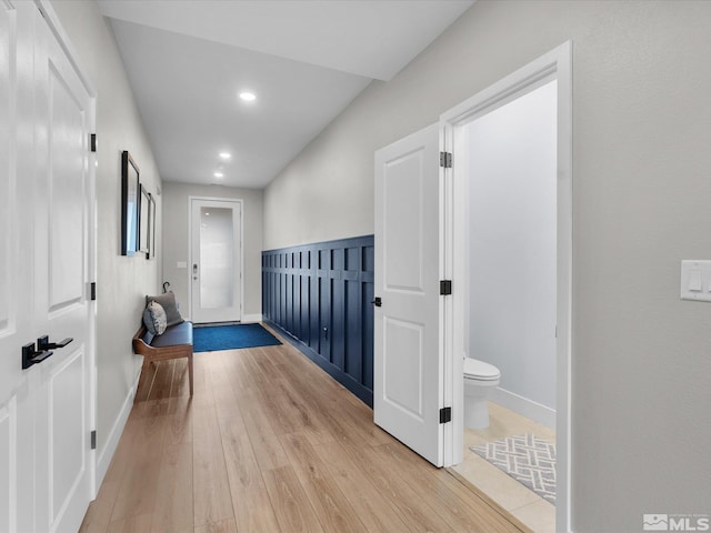 corridor featuring light wood-type flooring, recessed lighting, and baseboards