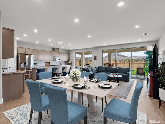 dining space with healthy amount of natural light, recessed lighting, and light wood-style flooring