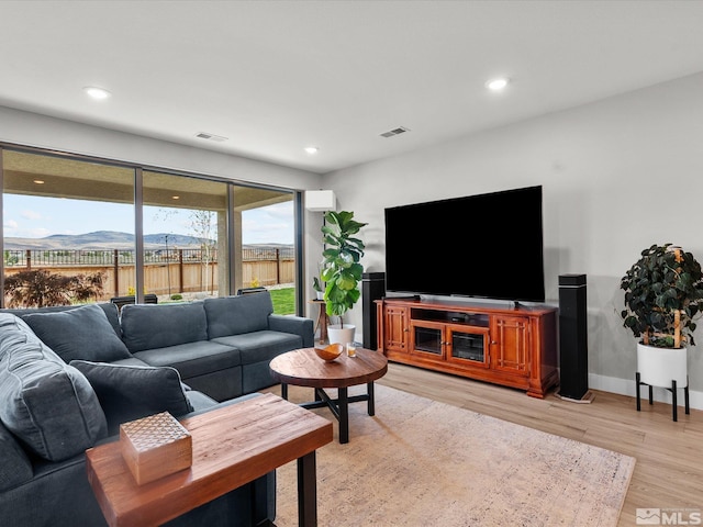 living room with light wood-type flooring, recessed lighting, and baseboards