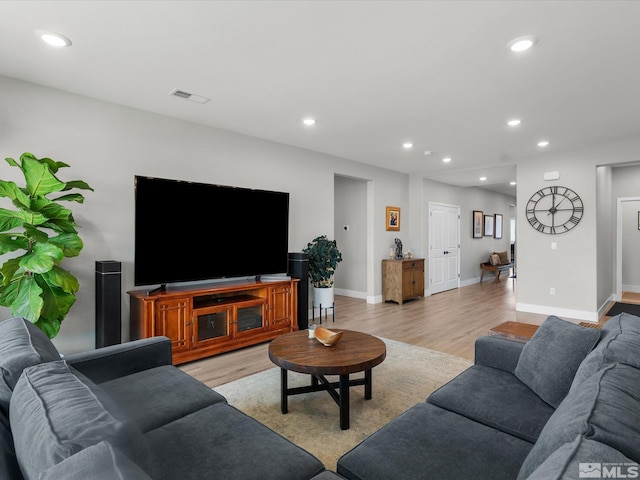 living room with light wood-style floors, recessed lighting, and baseboards