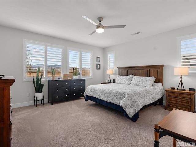 bedroom with baseboards, light colored carpet, and a ceiling fan