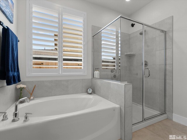 full bath featuring a shower stall, a garden tub, and tile patterned flooring